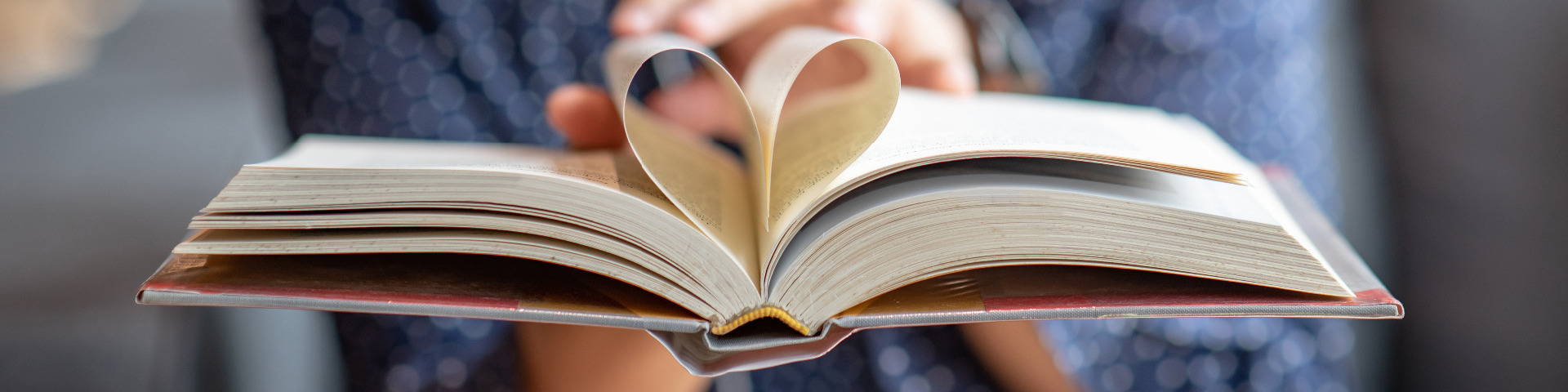 Open book with middle pages curled into a heart shape